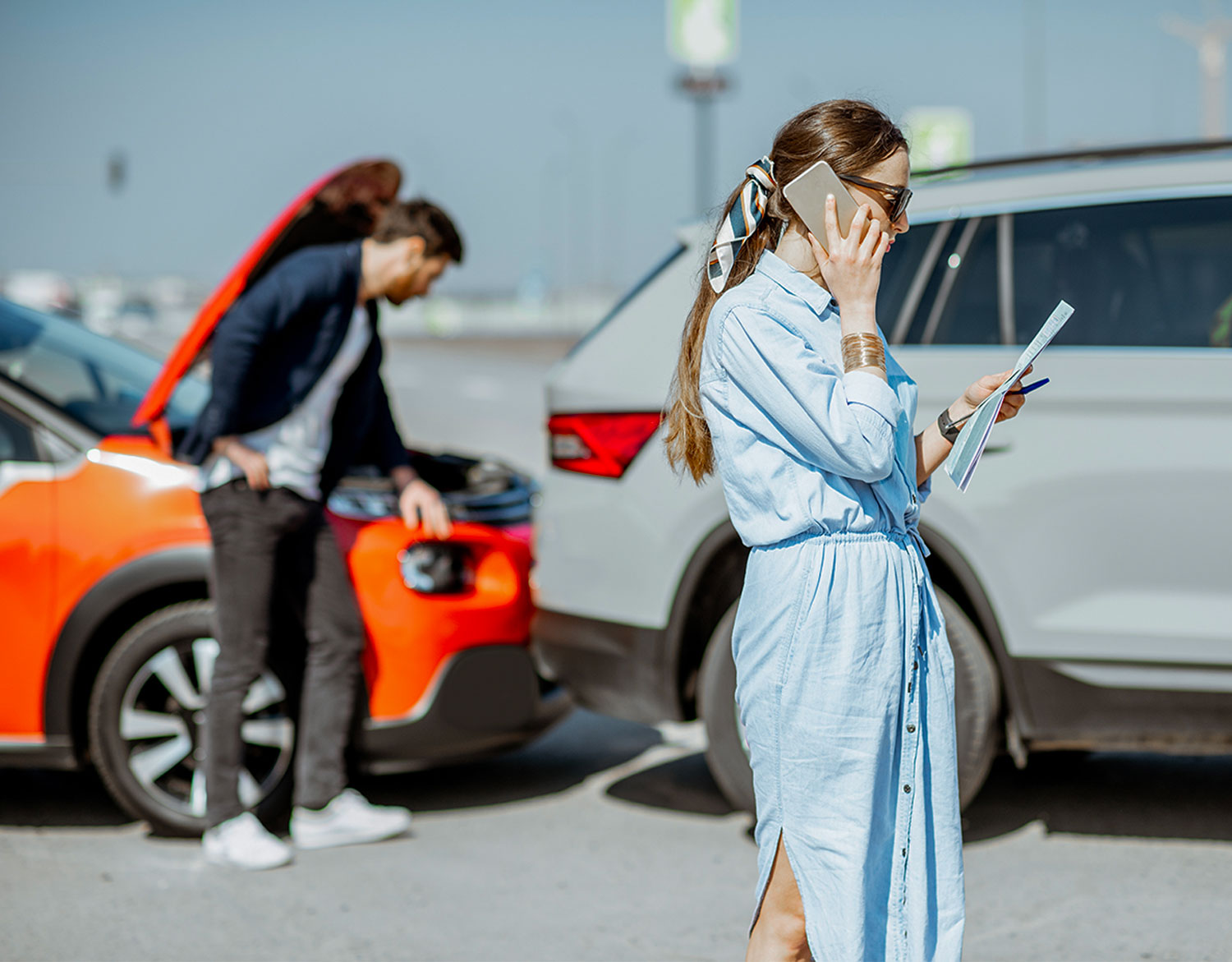 Un uomo e una donna discutono al telefono dopo un sinistro stradale
